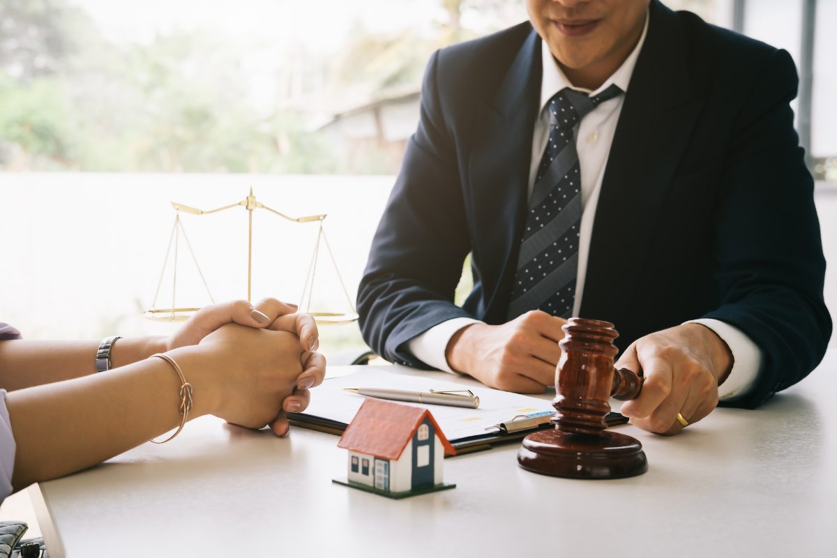 Abogado inmobiliario con balanza de la justicia y modelo de casa